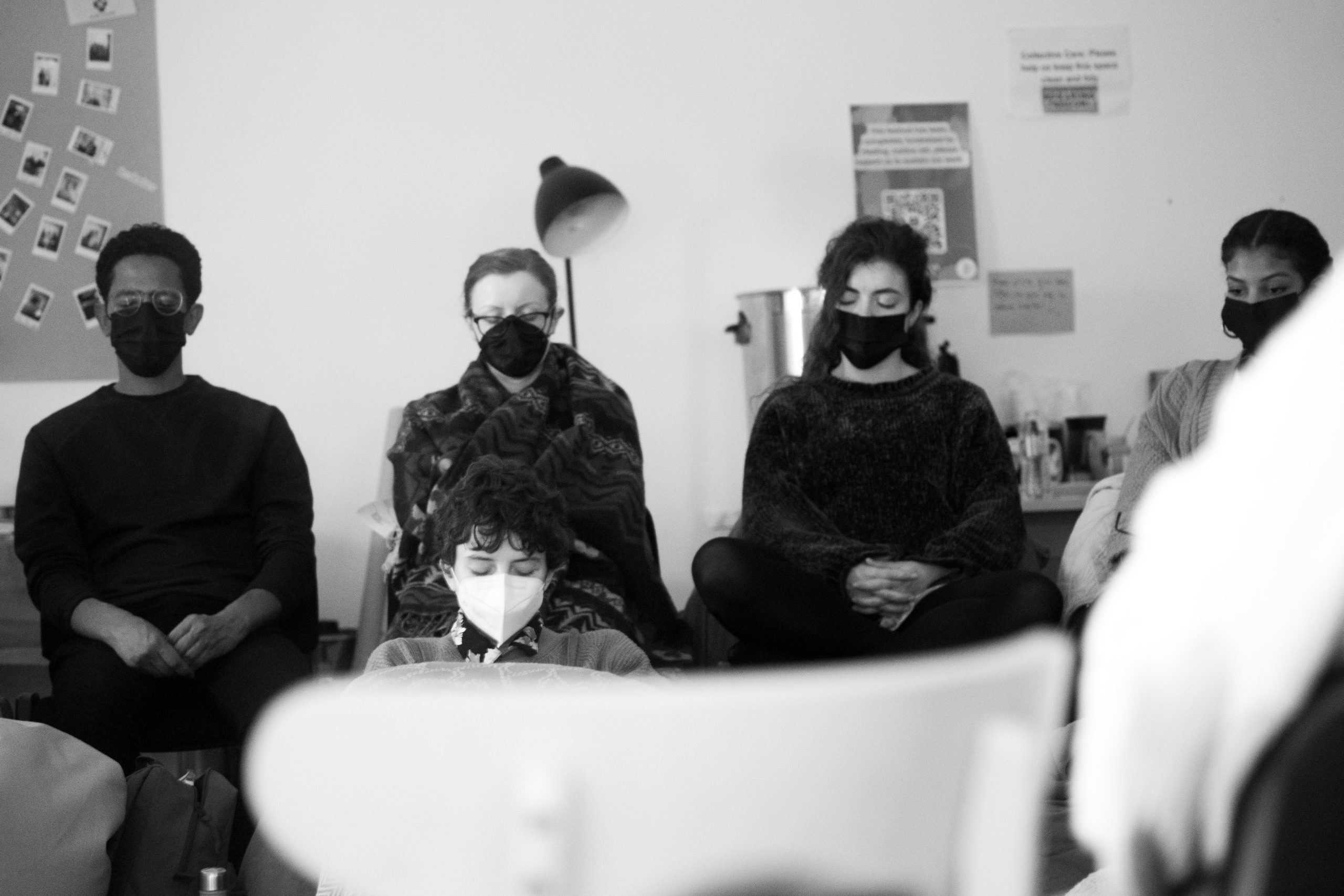 five people sitting with their eyes closed
