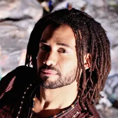 close up of Sai Murray, a Black man with locs and a short beard