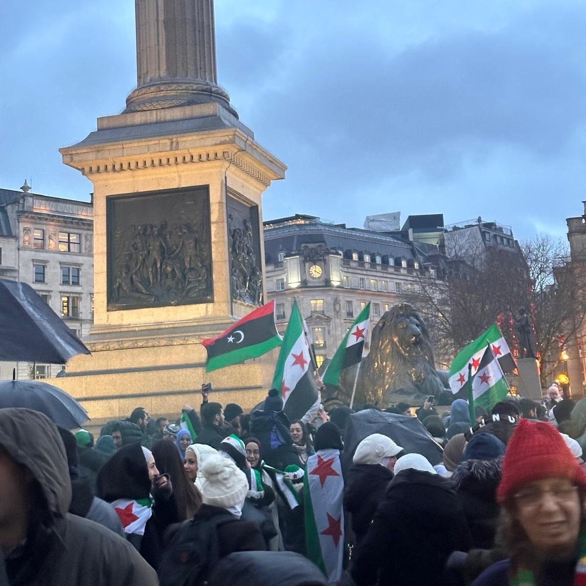 View of Trafalgar square following the fall of Assad A crowd stands in front of Nelson's column with Syrian flags