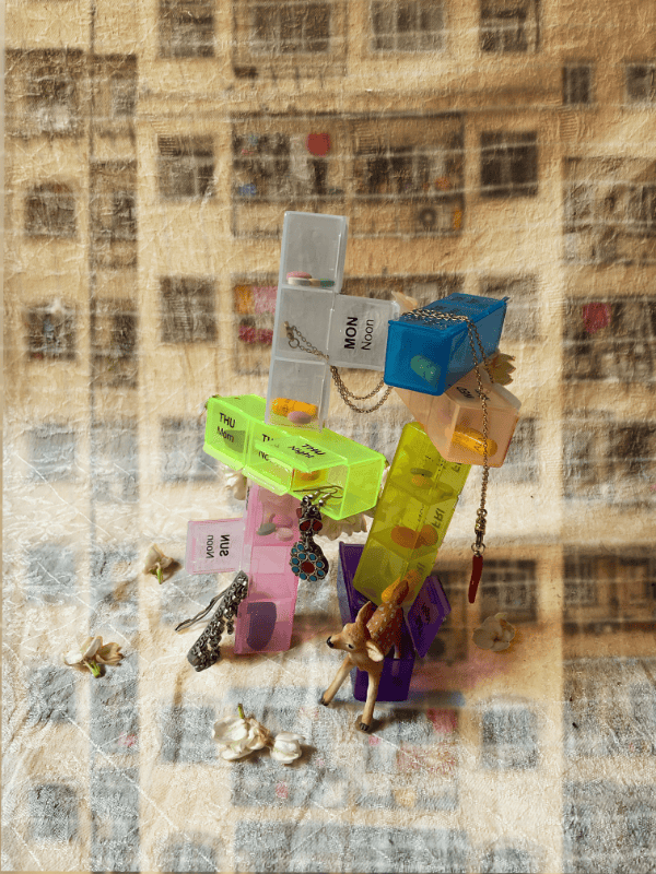 A stack of colourful pill boxes and small trinkets create a mini tower 